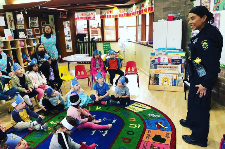 Police officer talking to kids in a classroom